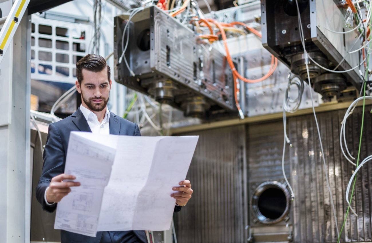 Businessman in factory looking at plan